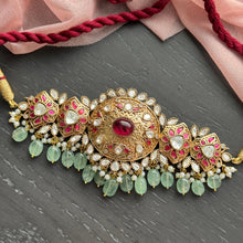 Load image into Gallery viewer, Ornate gold and gemstone necklace on a dark surface with pink fabric and red cord.

